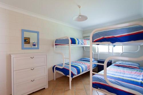 Blueys Beach Villa Manyana 24 في بلويز بيتش: غرفة نوم مع سريرين بطابقين وخزانة