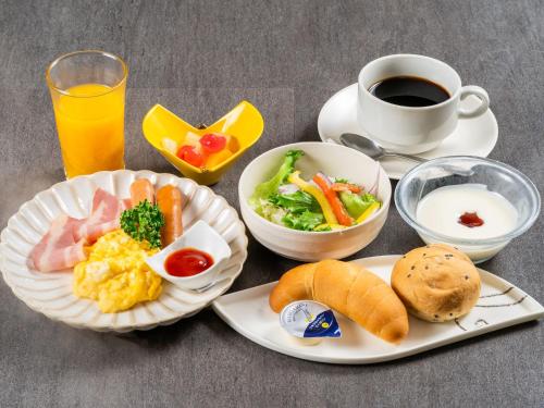 un tavolo con piatti per la colazione e una tazza di caffè di Matsuura City Hotel a Matsuura