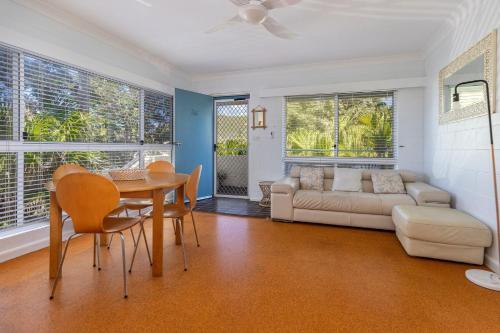 a living room with a table and chairs and a couch at Blueys Beach Villa Manyana 26 in Blueys Beach