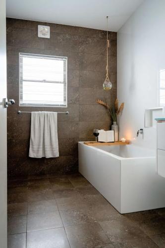 a bathroom with a bath tub and a window at The Emerald Bower Peaceful Kilaben Bay Hideaway in Rathmines