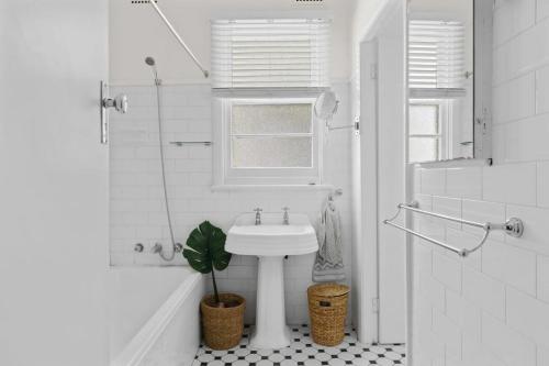 Hilltop Hideaway Family Escape في Merewether: حمام ابيض مع مغسلة ومصنع