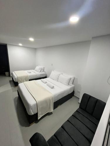 a room with two beds and a chair in it at Apartamento moderno, central, inteligente y totalmente equipado in Duitama