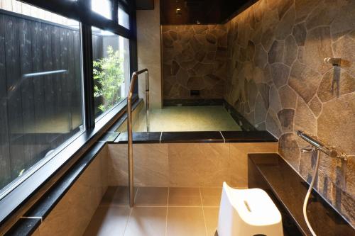 a bathroom with a shower with a toilet and a window at HATAGO HIKONE - Annex in Hikone