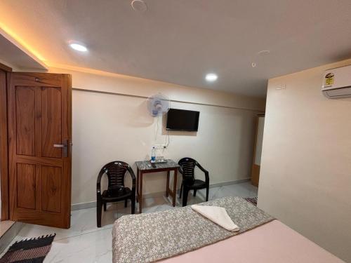 a bedroom with a table and chairs and a bed at Ambassador Stayz By JA Luxus in Jāmb