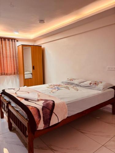 a bedroom with a large bed with a wooden frame at Ambassador Stayz By JA Luxus in Jāmb