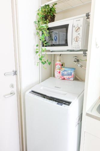 a small kitchen with a white washer and dryer at ハイクレスト中野202 in Tokyo