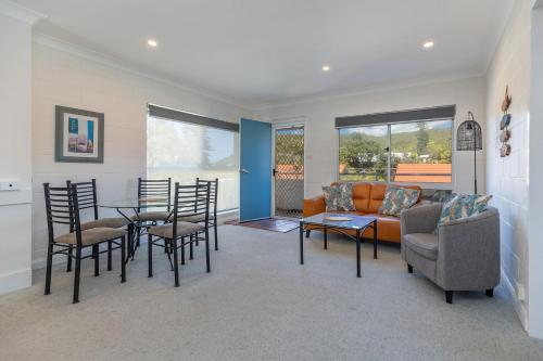 a living room with a couch and a table and chairs at Blueys Beach Villa Manyana 30 in Blueys Beach