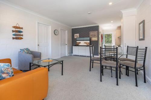 a living room with a couch and a table and chairs at Blueys Beach Villa Manyana 30 in Blueys Beach
