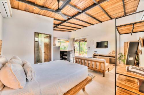 a bedroom with a bed and a living room at Salt n Pepper - Rosemary Villa with shared Pool - Adults Only in Puerto Viejo