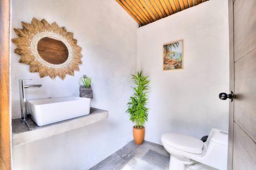 a bathroom with a toilet and a sink and a mirror at Salt n Pepper - Rosemary Villa with shared Pool - Adults Only in Puerto Viejo
