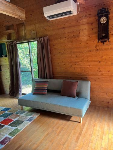 a couch in a room with a wall with a clock at ペシュール ヤクシマ in Funayuki