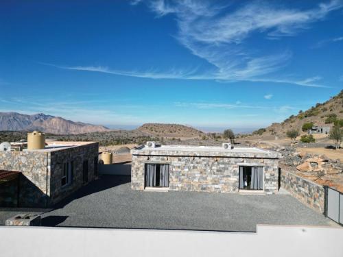 Dār SawdāʼClimbing Guest House Jebel Shams的一座可以看到沙漠景色的石屋