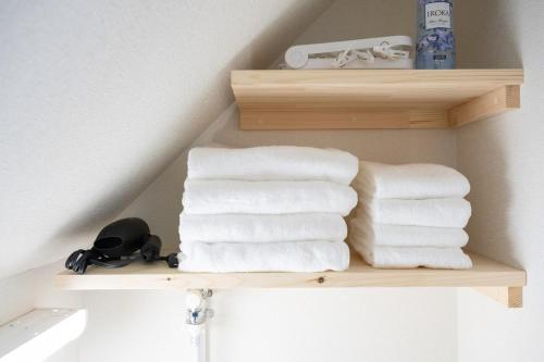 a pile of towels on a shelf in a bathroom at NAGI setouchi in Takamatsu