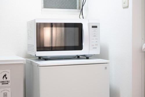 a microwave sitting on top of a refrigerator at NAGI setouchi in Takamatsu