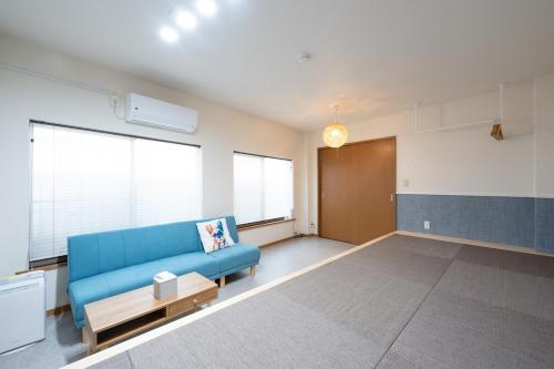 a living room with a blue couch in a room at NAGI setouchi in Takamatsu