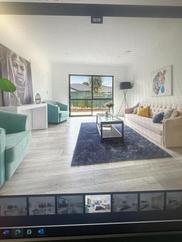 a television screen showing a living room with couches at Airport Heaven Comfort Home in Auckland