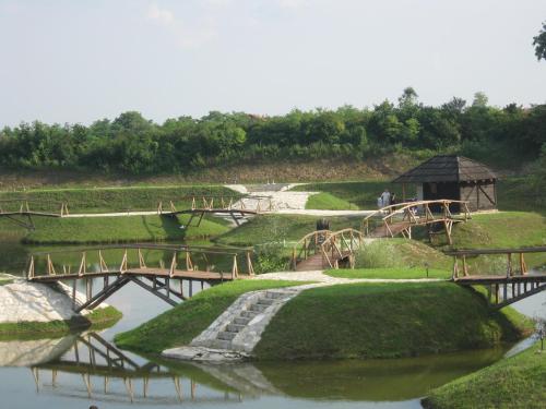 a park with a bridge over a river with grass at Etno Selo Moravski Konaci in Velika Plana