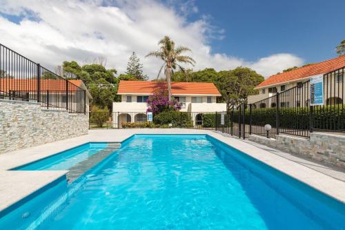 a swimming pool in front of a house at Blueys Beach Villa Manyana 26 in Blueys Beach