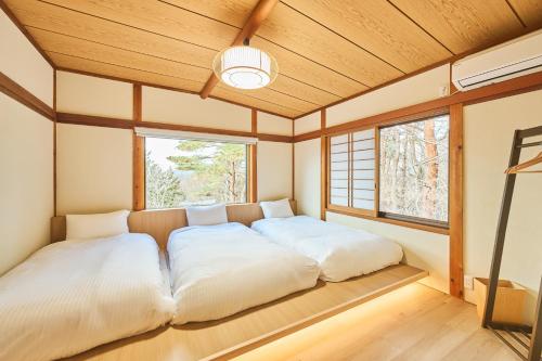 En eller flere senge i et værelse på プライベートリゾート星池