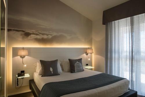 サン・ジョヴァンニ・ロトンドにあるAriae Dépendance - Alihotelsのベッドルーム1室(壁に絵画が描かれたベッド1台付)