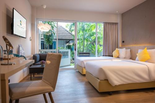 a hotel room with two beds and a desk at Samui Natien Resort in Chaweng