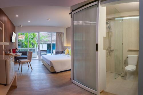 a hotel room with a bed and a bathroom at Samui Natien Resort in Chaweng
