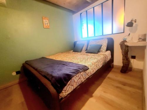 ein kleines Bett in einem Zimmer mit Fenster in der Unterkunft L'Echappée Tropicale - L'Echappée Mer, ma cabane de surf in L’Étang-Salé