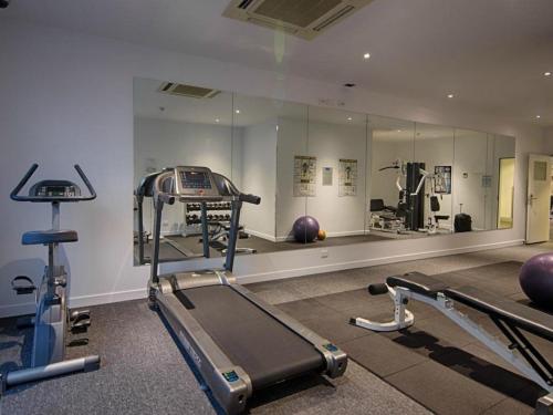a gym with two tread machines and a mirror at Richmond Central Apartments in Melbourne