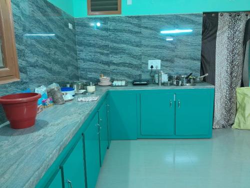 a kitchen with blue cabinets and a sink at RKGroupStays in Tirupati