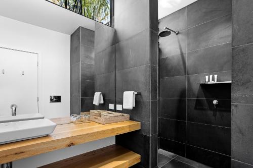 Privately Managed Golf View - Bangalay Villas في Shoalhaven Heads: حمام مع حوض ومرآة