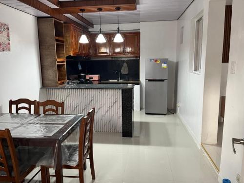 een keuken met een eettafel en een koelkast bij Jorich home stay in Dumaguete