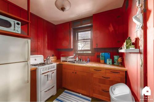 a kitchen with red walls and a white refrigerator at Charming Garden Cottage & Walk to UC & BART & Parking in Berkeley