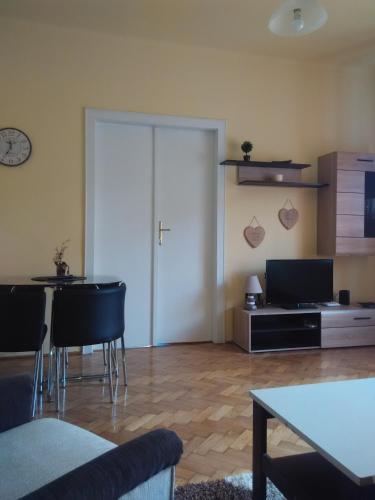 a living room with a table and chairs and a door at Anna Apartmanok in Pécs