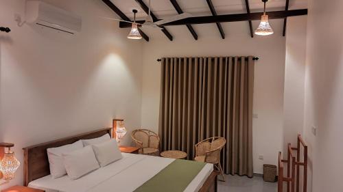 a bedroom with a bed and some lights and chairs at The Clouds Ahangama in Ahangama
