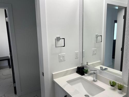 a white bathroom with a sink and a mirror at Private room with full washroom in Edmonton