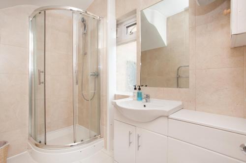 a white bathroom with a shower and a sink at D'Arblay Studio's Soho in London