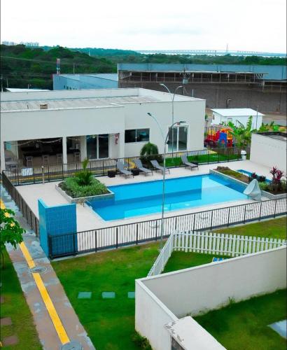 a building with a swimming pool in a yard at Ponta Negra Apartment in Manaus