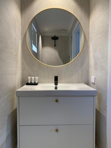 a bathroom with a white sink and a mirror at Dongara Tourist Park in Port Denison