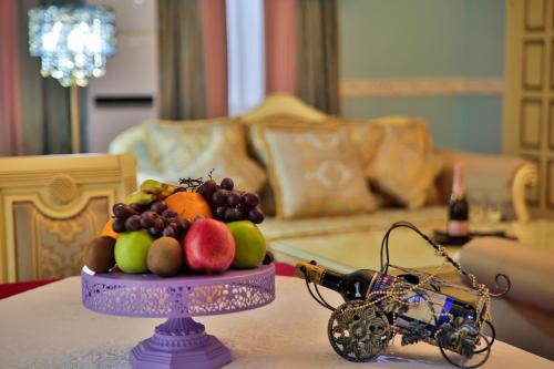 a table with a plate of fruit and a toy car at Amsterdam Hotel Aktobe in Aktobe