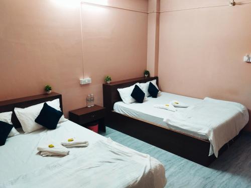 two beds in a hotel room with towels on them at Hotelroyalcrown in Jāmb