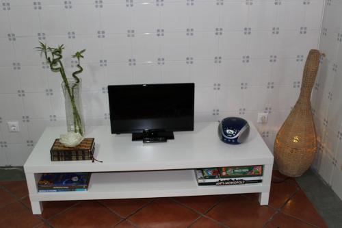 a white table with a television and a guitar at Hello Terceira in Angra do Heroísmo