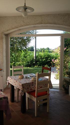 mesa de comedor con 2 sillas y ventana en B&B Casa Perini en Villa Vicentina