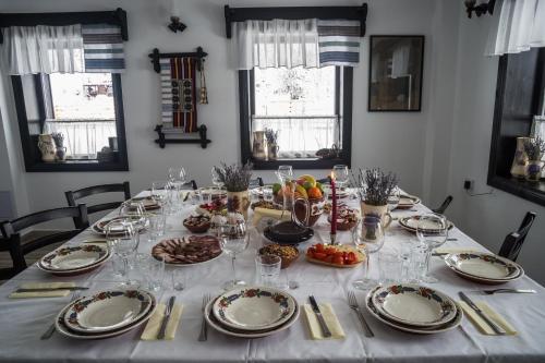 a table with plates and wine glasses on it at Pensiunea La Moară in Fundu Moldovei