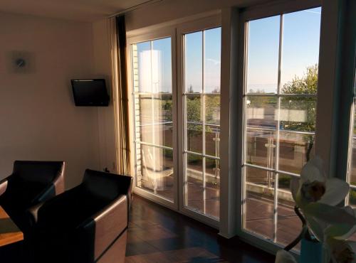 a living room with a large window with a view at Heiligenhafen Doppel-Seeblick in Heiligenhafen