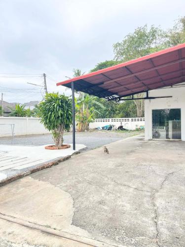 a gas station with a dog under a red roof at CozyRooms Korat in Ban Nong Bo