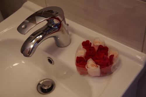 a sink with a bunch of roses in a container at Chata pod Mogielicą komfortowe pokoje z widokiem na Mogielicę 1000m od tras wokół góry Mogielica in Słopnice