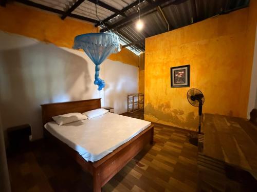a bedroom with a bed and a blue chandelier at Coconut Beach in Bentota