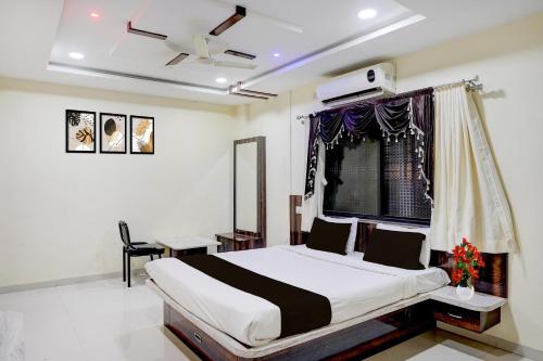Collection O Daulatabad Fort Aurangabad Formerly JVS Park Inn في Daulatābād: غرفة نوم مع سرير ونافذة مع مروحة سقف