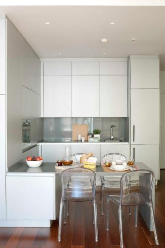 a kitchen with white cabinets and a table and chairs at Eric Vökel Boutique Apartments - Madrid Suites in Madrid