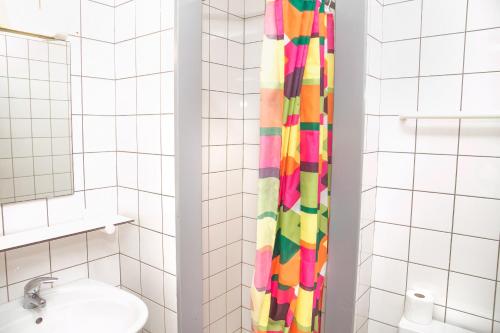 ein Badezimmer mit einem farbenfrohen Duschvorhang neben einem Waschbecken in der Unterkunft Hostel Europa in Brügge